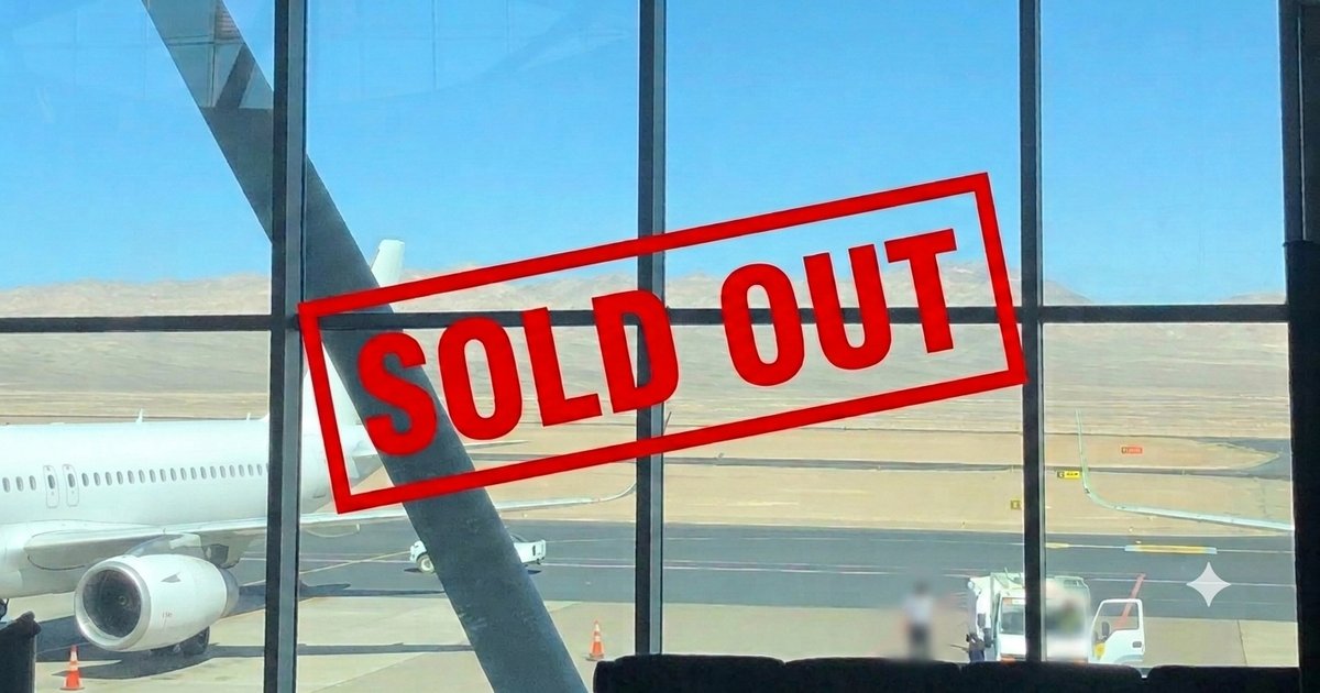 空港の窓越しに見える飛行機に、赤い「SOLD OUT」のスタンプが重なっている写真。安さを追いかけて直行便を逃した失敗談をイメージした一枚