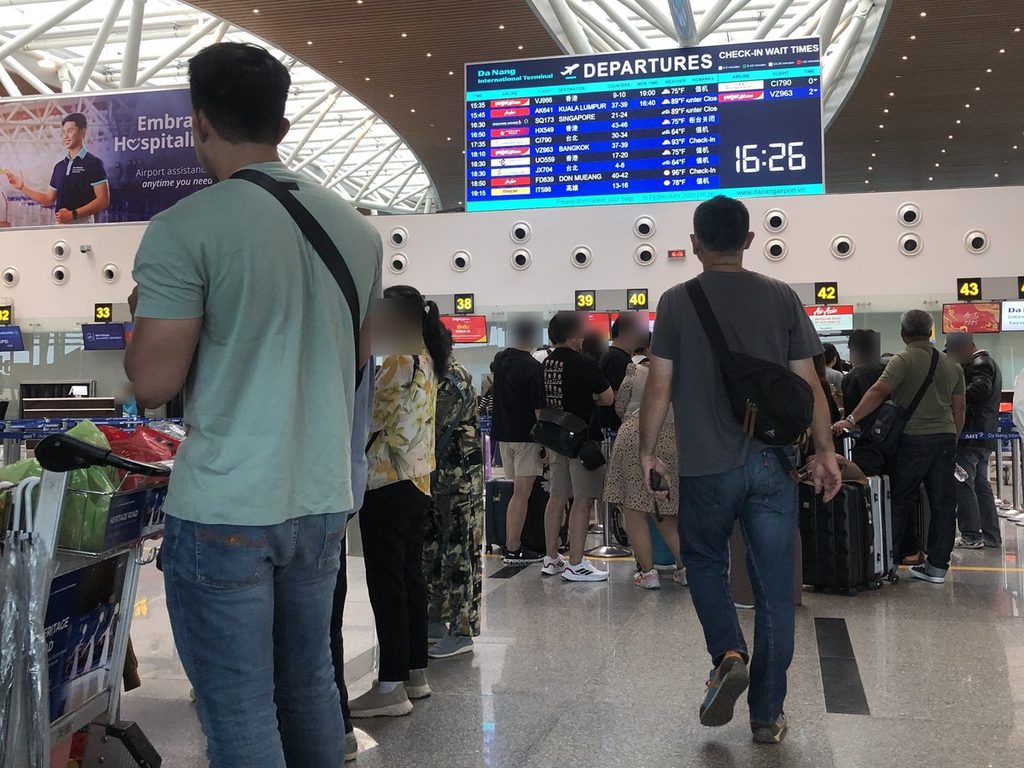 ダナン国際空港の出発ロビー。夕方の便のチェックインカウンターに旅行者の列ができている