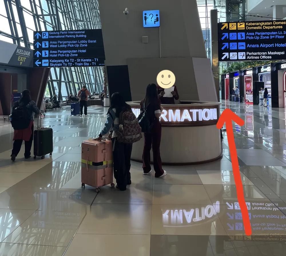 到着ロビーの案内所。ATMへの道を赤い矢印で示している