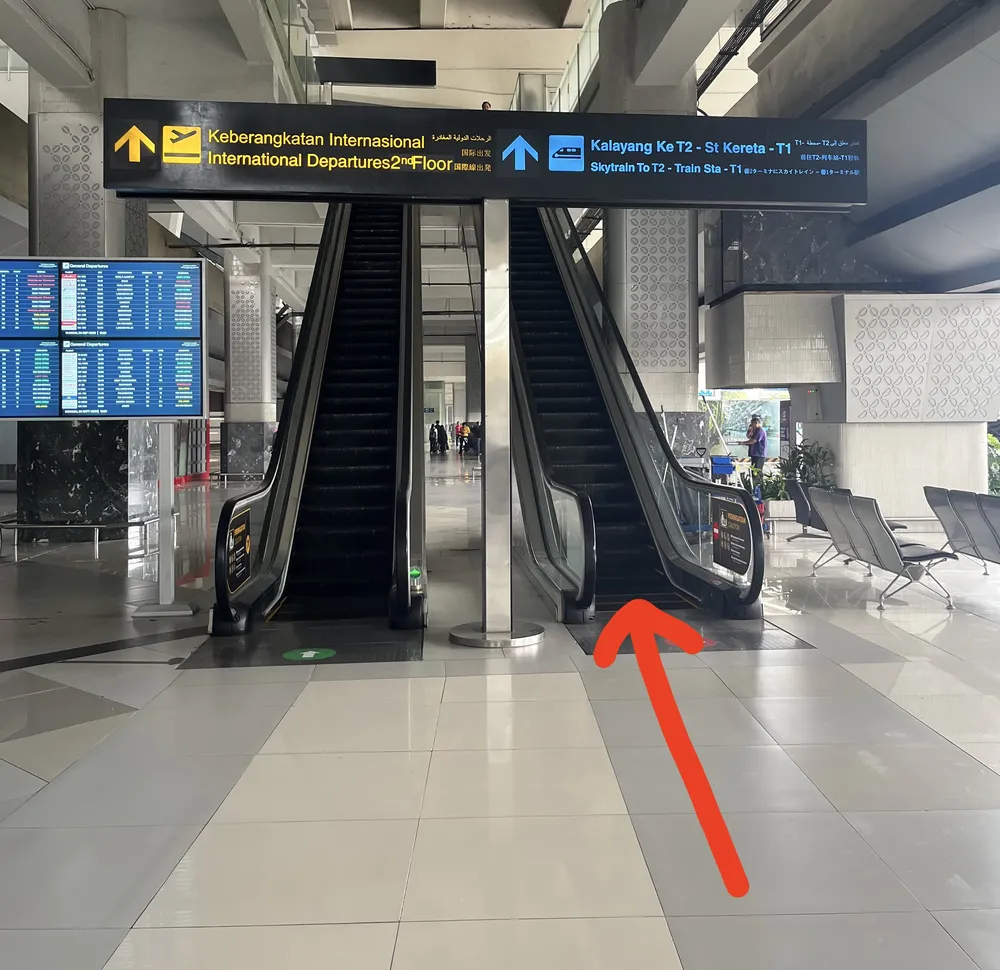 スカイトレインと鉄道駅の案内があるエスカレーター
