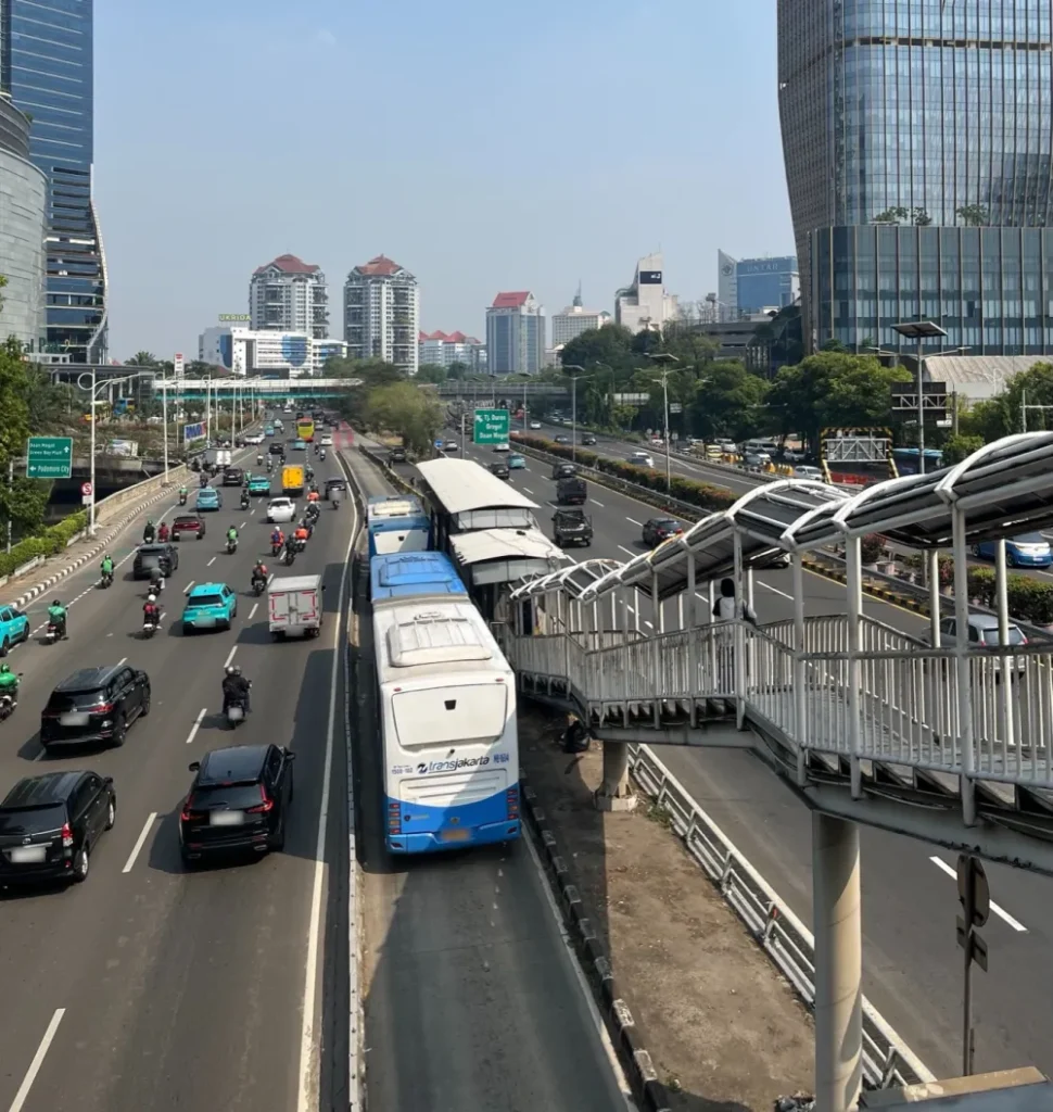 歩道橋から見た大通り。道の真ん中の専用レーンをバスが走り、その先にバス停がある