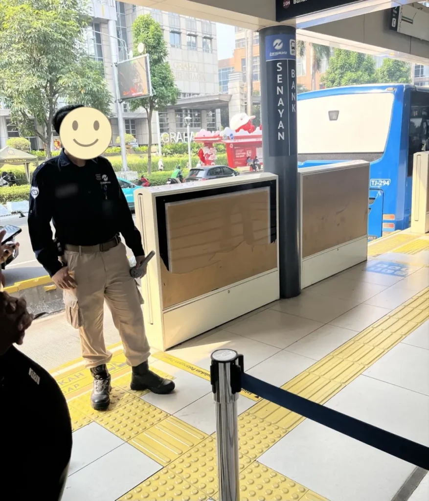 SENAYAN BANKのバス停に立つ係員。乗り場以外は柵で囲まれている