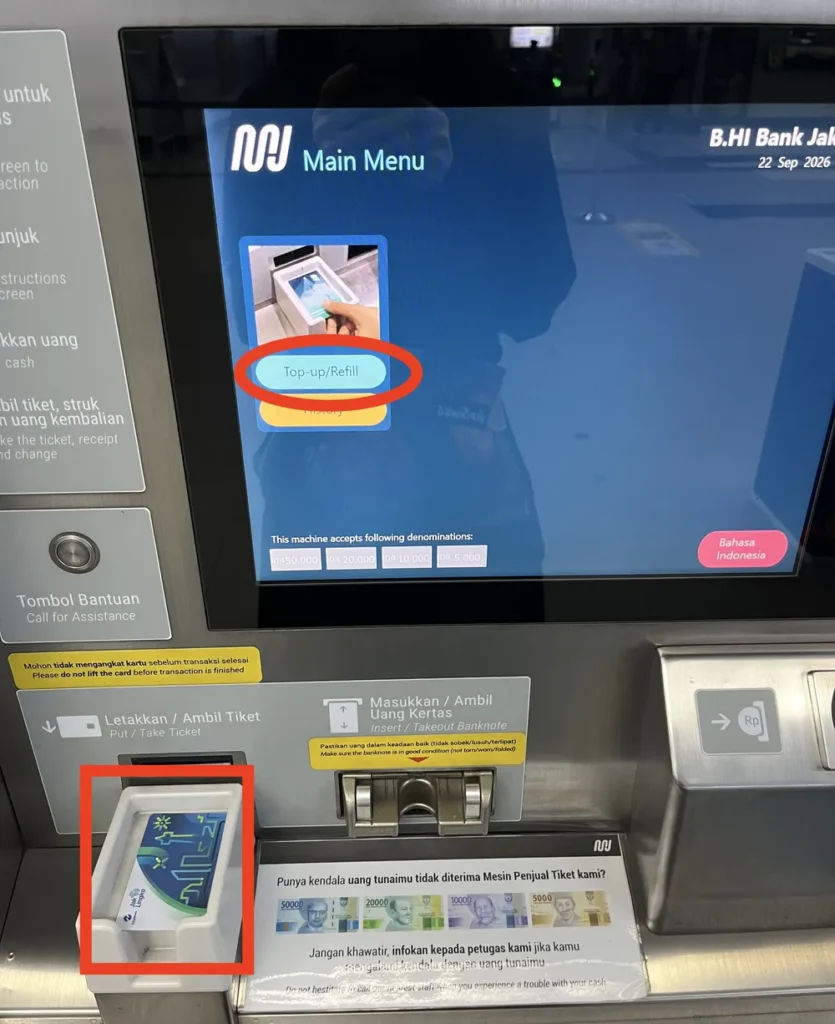 駅の券売機のメニュー画面。「Top-up/Refill」のボタンを赤丸、カードを置いたトレイを赤枠で囲んでいる