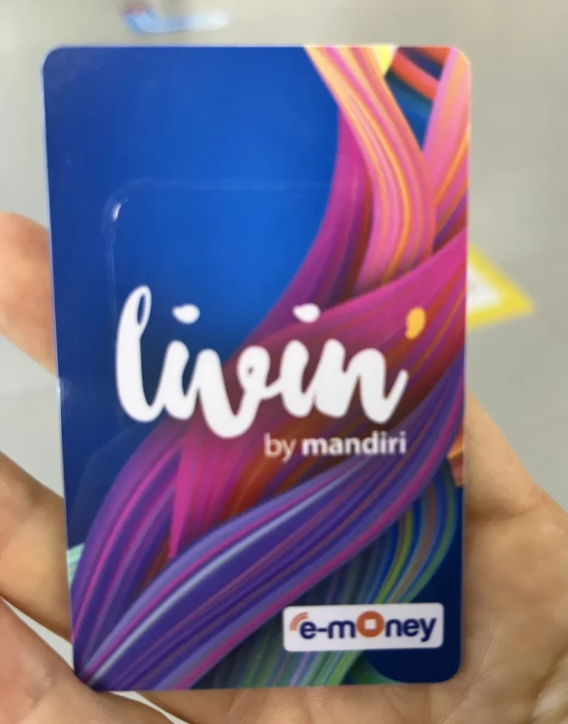 コンビニで買ったmandiri e-moneyのカードを手に持っている